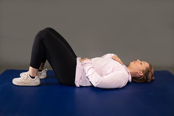 woman doing breathing exercises postpartum